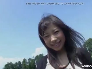 क्यूट एशियन लड़की फैलता लेग्स सड़क पर के लिए अच्छा उंगली.